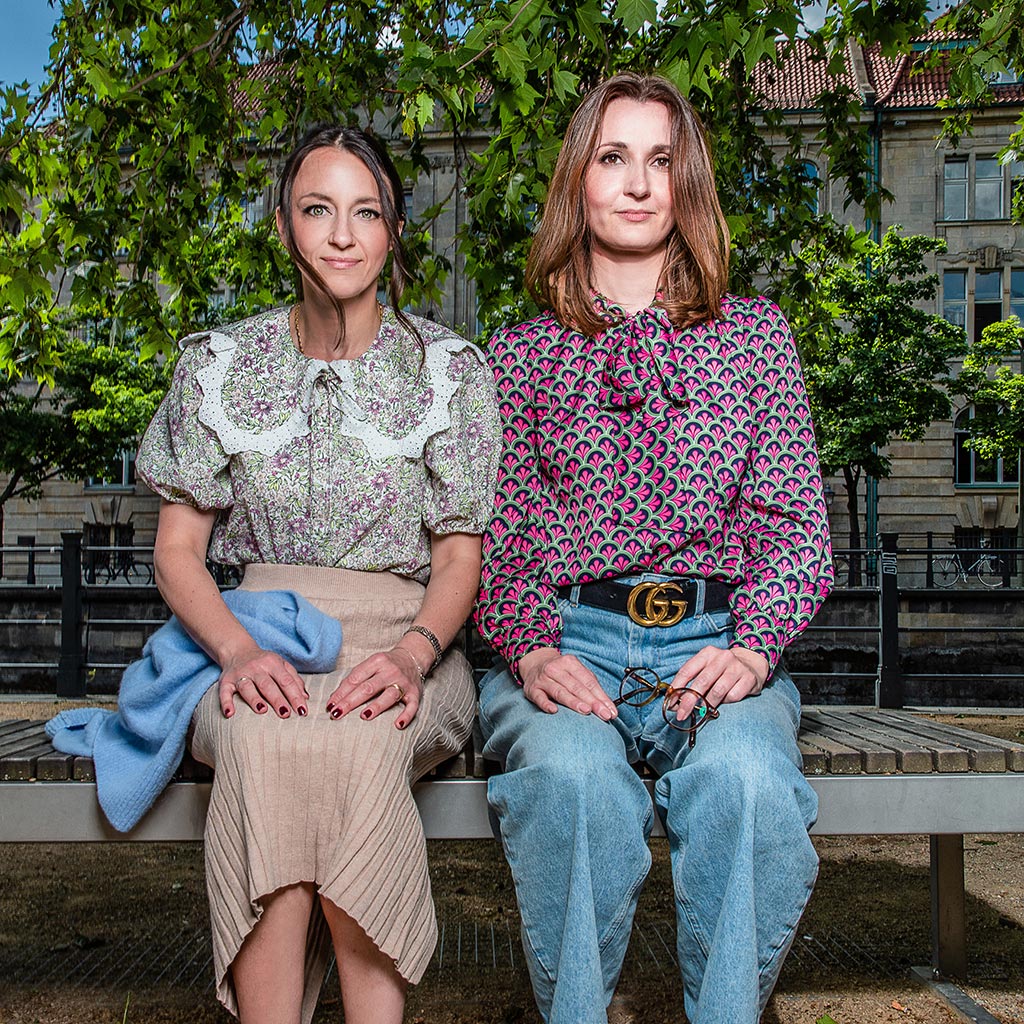 zwei Frauen sitzen nebeneinander auf einer Bank