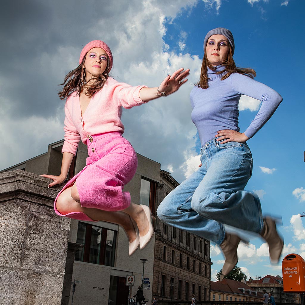 Two women jump in the air